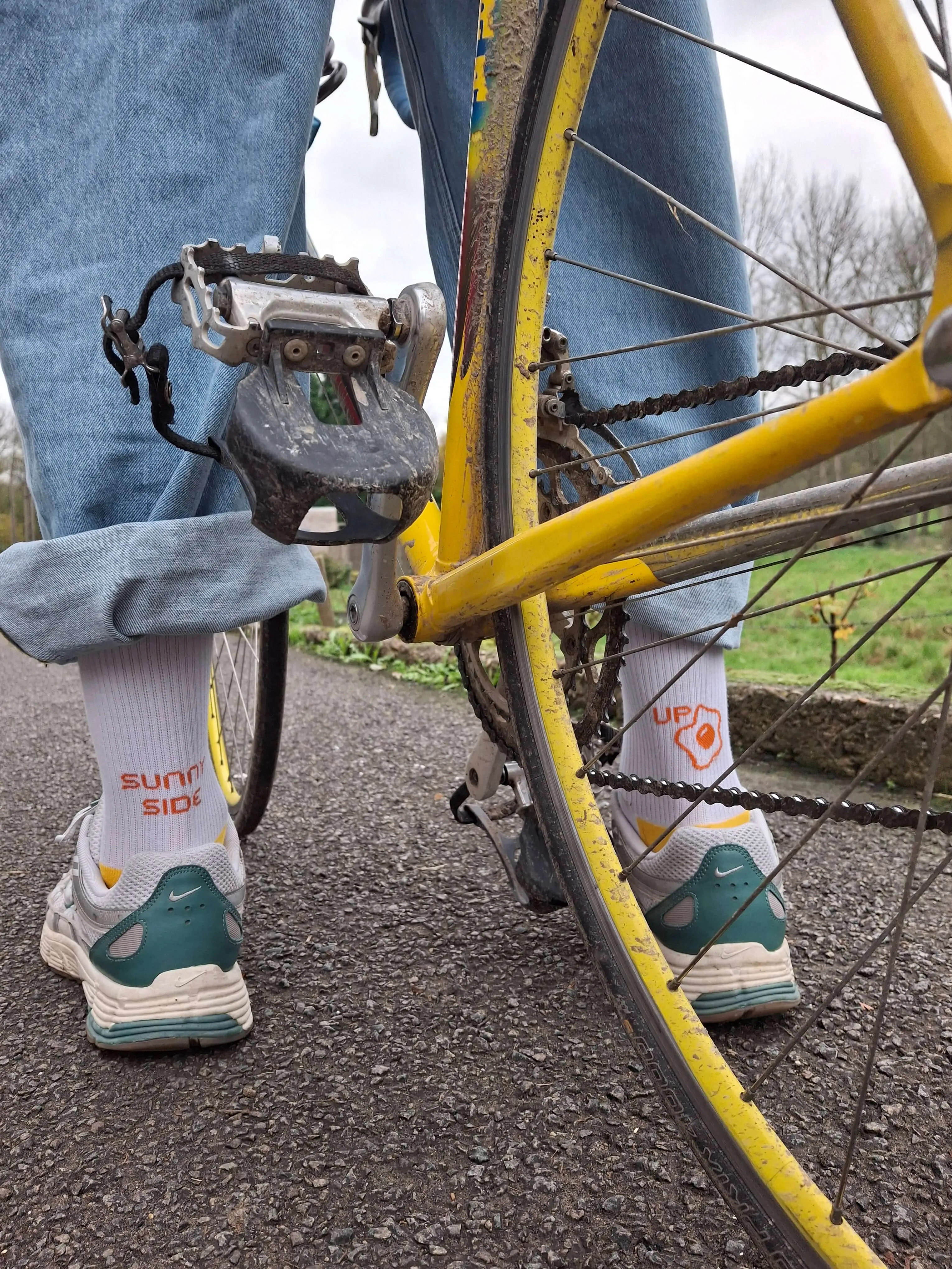 Person on a bike wearing the 'Sunny Side Up' socks and green Nike shoes